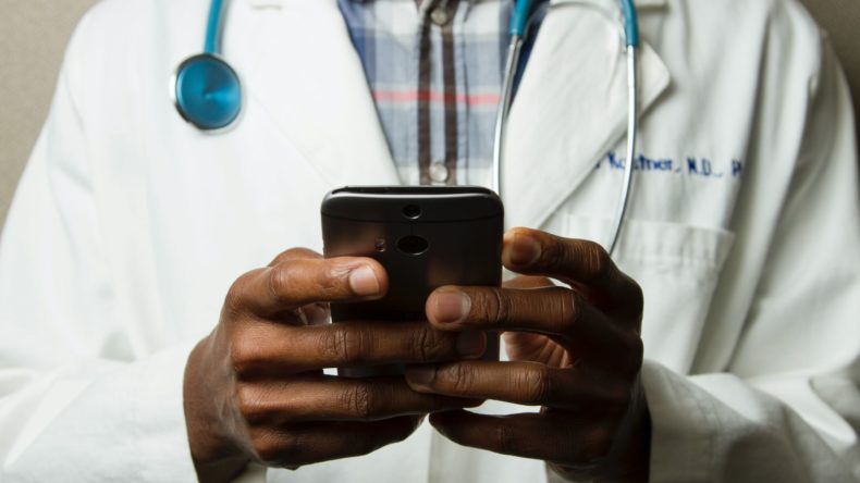 doctor reading notes on phone