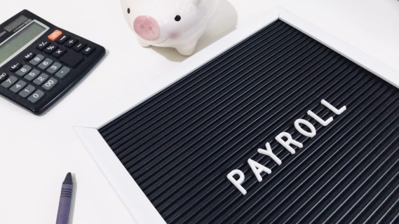 payroll with calculator and piggy bank